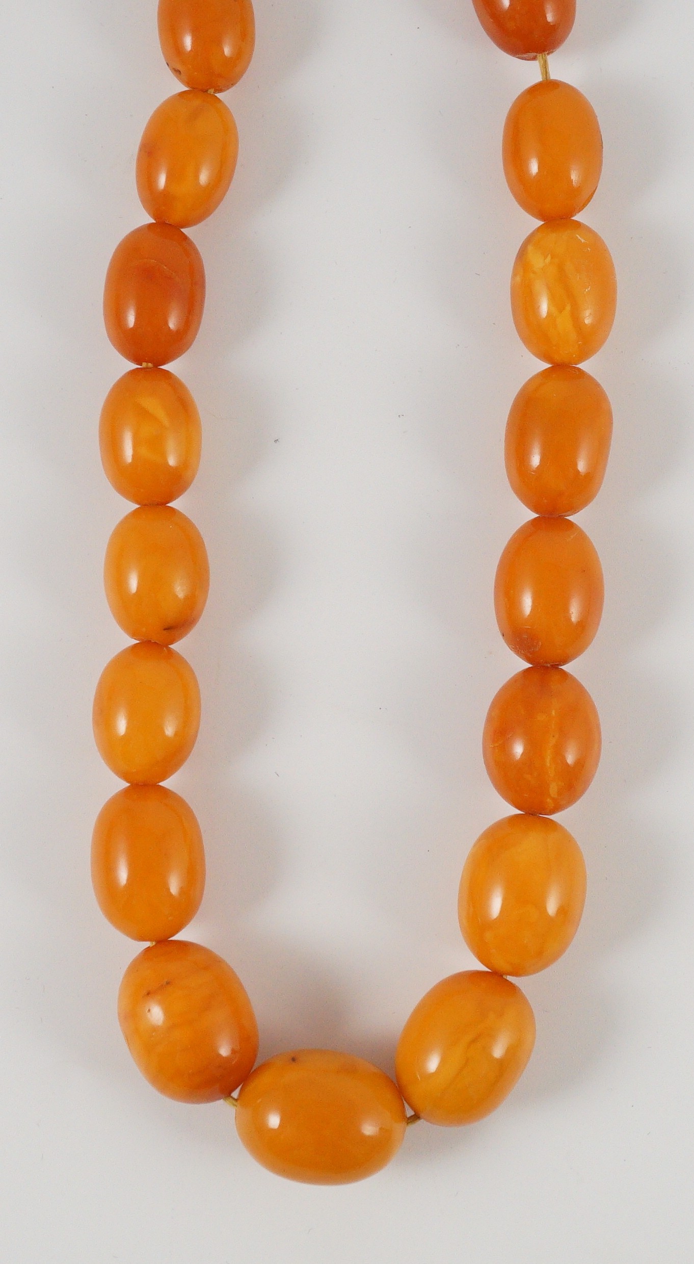 A single stand graduated oval amber bead necklace, 76cm, gross weight 85 grams.